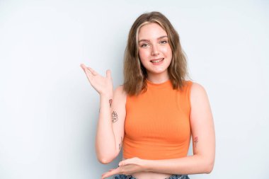 caucasian pretty woman smiling proudly and confidently, feeling happy and satisfied and showing a concept on copy space