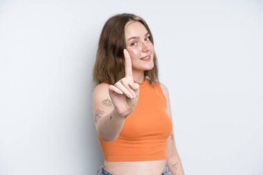 caucasian pretty woman smiling proudly and confidently making number one pose triumphantly, feeling like a leader