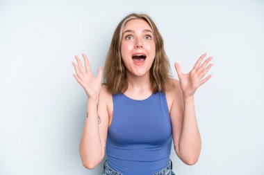 caucasian pretty woman feeling happy, amazed, lucky and surprised, celebrating victory with both hands up in the air