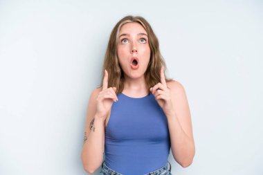 caucasian pretty woman feeling awed and open mouthed pointing upwards with a shocked and surprised look