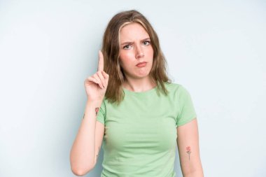 caucasian pretty woman feeling like a genius holding finger proudly up in the air after realizing a great idea, saying eureka