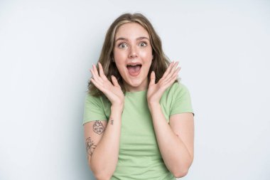 caucasian pretty woman feeling shocked and excited, laughing, amazed and happy because of an unexpected surprise