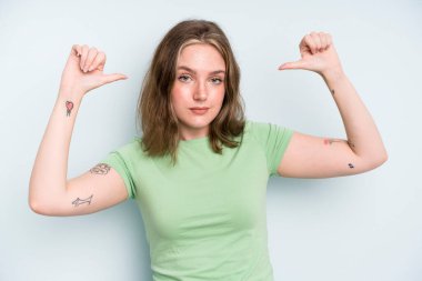 caucasian pretty woman feeling proud, arrogant and confident, looking satisfied and successful, pointing to self