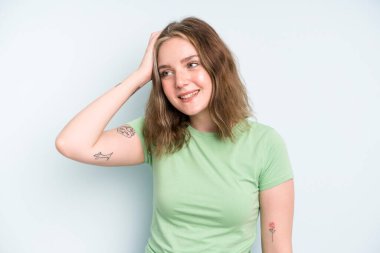 caucasian pretty woman smiling cheerfully and casually, taking hand to head with a positive, happy and confident look