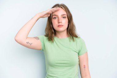 caucasian pretty woman greeting the camera with a military salute in an act of honor and patriotism, showing respect