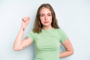 caucasian pretty woman feeling serious, strong and rebellious, raising fist up, protesting or fighting for revolution