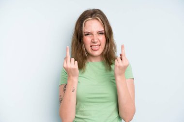 caucasian pretty woman feeling provocative, aggressive and obscene, flipping the middle finger, with a rebellious attitude