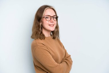 caucasian pretty woman smiling to camera with crossed arms and a happy, confident, satisfied expression, lateral view