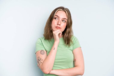 caucasian pretty woman feeling thoughtful, wondering or imagining ideas, daydreaming and looking up to copy space