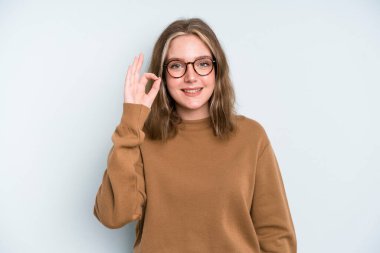 caucasian pretty woman feeling happy, relaxed and satisfied, showing approval with okay gesture, smiling