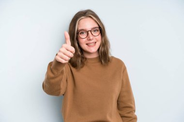 caucasian pretty woman feeling proud, carefree, confident and happy, smiling positively with thumbs up