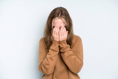 caucasian pretty woman feeling sad, frustrated, nervous and depressed, covering face with both hands, crying