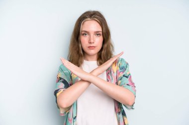 caucasian pretty woman looking annoyed and sick of your attitude, saying enough! hands crossed up front, telling you to stop