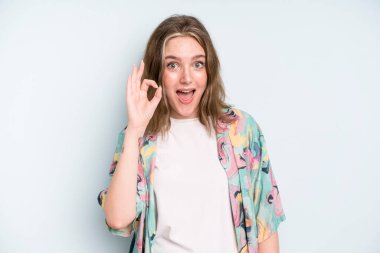 caucasian pretty woman feeling successful and satisfied, smiling with mouth wide open, making okay sign with hand