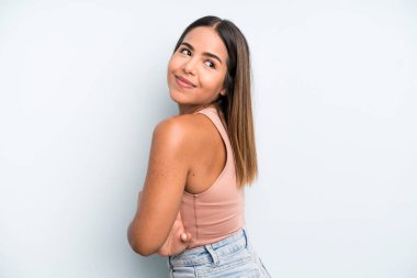 hispanic latin pretty woman smiling gleefully, feeling happy, satisfied and relaxed, with crossed arms and looking to the side