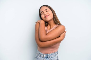 hispanic latin pretty woman feeling in love, smiling, cuddling and hugging self, staying single, being selfish and egocentric