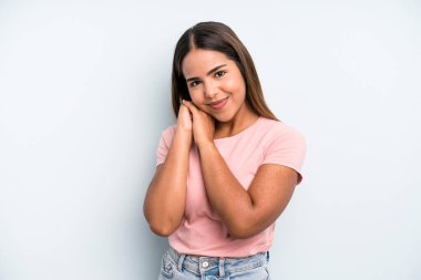 hispanic latin pretty woman feeling in love and looking cute, adorable and happy, smiling romantically with hands next to face