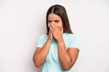 hispanic latin pretty woman looking happy, cheerful, lucky and surprised covering mouth with both hands