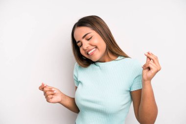 hispanic latin pretty woman smiling, feeling carefree, relaxed and happy, dancing and listening to music, having fun at a party