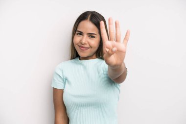 hispanic latin pretty woman smiling and looking friendly, showing number four or fourth with hand forward, counting down