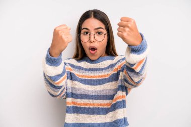 hispanic latin pretty woman celebrating an unbelievable success like a winner, looking excited and happy saying take that!