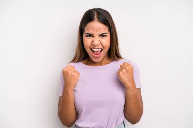 hispanic latin pretty woman shouting triumphantly, laughing and feeling happy and excited while celebrating success