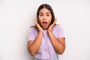 hispanic latin pretty woman feeling shocked and excited, laughing, amazed and happy because of an unexpected surprise