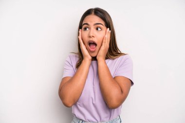 hispanic latin pretty woman feeling happy, excited and surprised, looking to the side with both hands on face