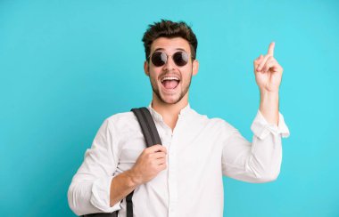 Bir çanta ve kitapla izole edilmiş genç yakışıklı bir adam. Üniversite öğrencisi konsepti