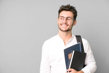 Bir çanta ve kitapla izole edilmiş genç yakışıklı bir adam. Üniversite öğrencisi konsepti