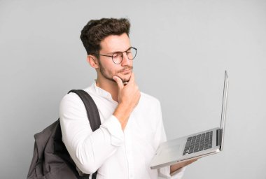 Genç ve yakışıklı bir adam dizüstü bilgisayarla izole edilmiş. Üniversite öğrencisi konsepti