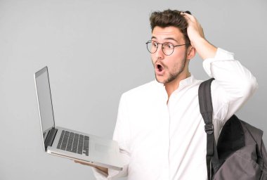 Genç ve yakışıklı bir adam dizüstü bilgisayarla izole edilmiş. Üniversite öğrencisi konsepti