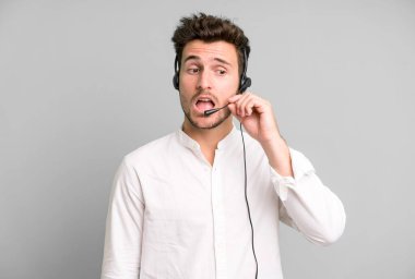 Operatör kulaklığı ve mikrofonuyla izole edilmiş genç yakışıklı bir adam. tele pazarlama kavramı