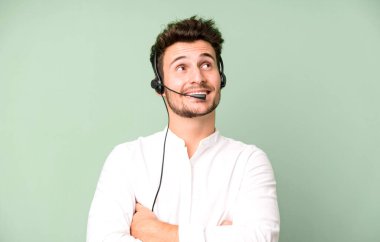 Operatör kulaklığı ve mikrofonuyla izole edilmiş genç yakışıklı bir adam. tele pazarlama kavramı