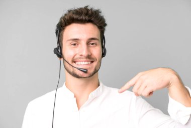 Operatör kulaklığı ve mikrofonuyla izole edilmiş genç yakışıklı bir adam. tele pazarlama kavramı