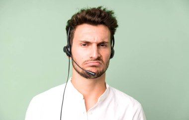 Operatör kulaklığı ve mikrofonuyla izole edilmiş genç yakışıklı bir adam. tele pazarlama kavramı