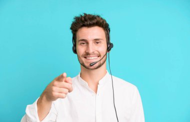 Operatör kulaklığı ve mikrofonuyla izole edilmiş genç yakışıklı bir adam. tele pazarlama kavramı