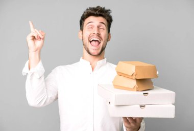 Fast food ile izole edilmiş genç yakışıklı adam kutuları taklit ediyor. teslimat ve paket konsepti
