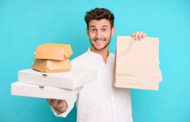 Fast food ile izole edilmiş genç yakışıklı adam kutuları taklit ediyor. teslimat ve paket konsepti