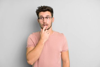 Şaşırmış, gergin, endişeli ya da korkmuş bakışları olan genç yakışıklı bir adam kopya boşluğuna bakıyor.