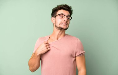 Genç ve yakışıklı bir adam stresli, endişeli, yorgun ve hayal kırıklığına uğramış, gömleğini çekiştirmiş, sorunlu görünüyor.