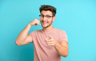 Genç yakışıklı adam neşeyle gülümsüyor ve kamerayı işaret ediyor. Sonra seni arıyor, telefonla konuşuyor.