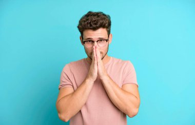 Genç, yakışıklı, endişeli, umutlu ve dindar bir adam. Avuçlarına bastırılmış, af dileyen sadık bir şekilde dua ediyor.