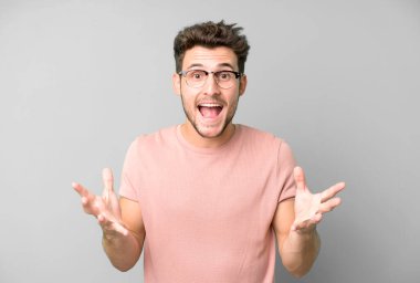 Genç yakışıklı adam kendini mutlu, şaşkın, şanslı ve şaşırmış hissediyor. İnanılmaz!