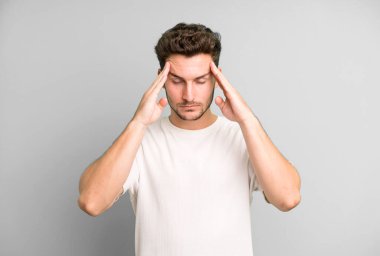 Genç ve yakışıklı bir adam stresli ve hayal kırıklığına uğramış görünüyor. Baskı altında çalışıyor ve sorunları var.