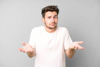 Genç yakışıklı bir adam bilgisiz ve kafası karışık, hangi seçeneği seçeceğinden emin değil, merak ediyor.