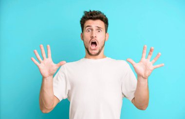 Genç yakışıklı adam sersemlemiş ve korkmuş hissediyor. Korkutucu bir şeyden korkuyor. Elleri açık ve uzak dur diyor.