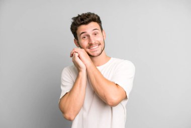 Genç, yakışıklı bir adam aşık ve sevimli görünüyor. Sevimli ve mutlu. Romantik bir şekilde gülümsüyor.