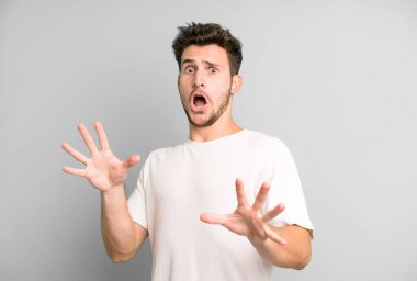 Dehşete kapılmış genç yakışıklı bir adam korku ve panik içinde geri çekiliyor ve bir kabusa tepki veriyor.