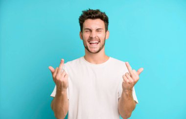 Genç yakışıklı adam kışkırtıcı, agresif ve müstehcen hissediyor. İsyankar bir tavırla orta parmağını hareket ettiriyor.